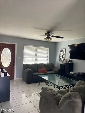 a living room with furniture a window and a flat screen tv