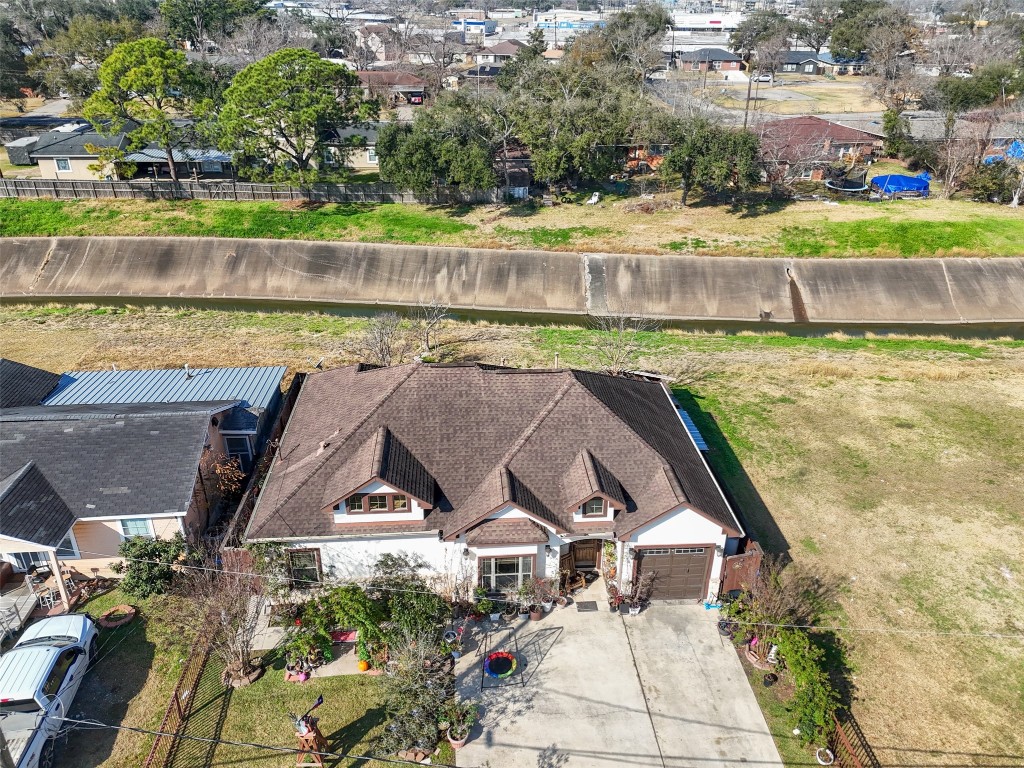 an aerial view of a house with a yard lake and ocean view