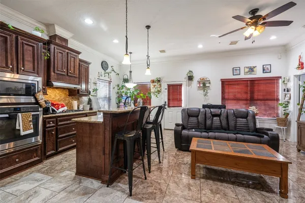 a living room with stainless steel appliances kitchen island granite countertop furniture and a kitchen view