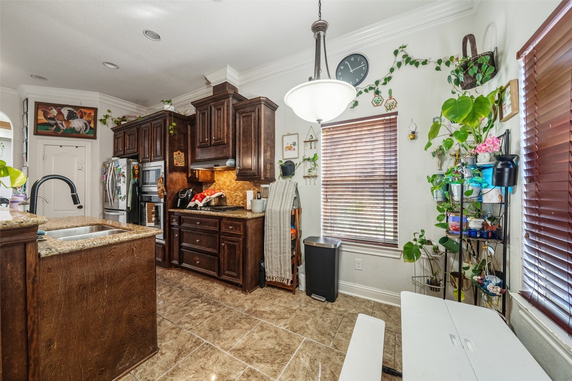 1508 Miami Road Pasadena, TX 77502 - Photo 15 of 34 a kitchen with stainless steel appliances kitchen island granite countertop a sink a stove and a wooden floor