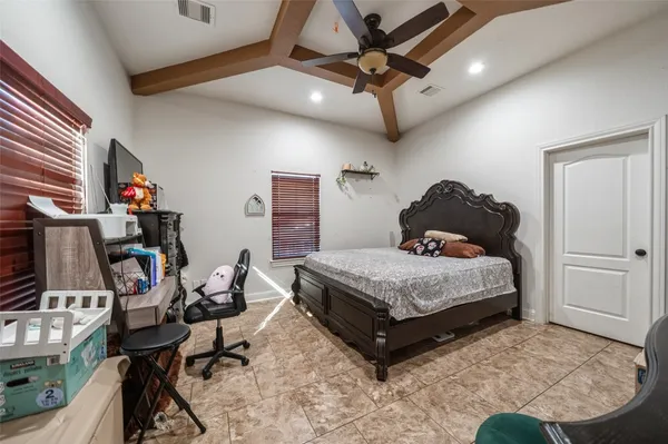 a bedroom with a bed a desk and chair with the potted plants