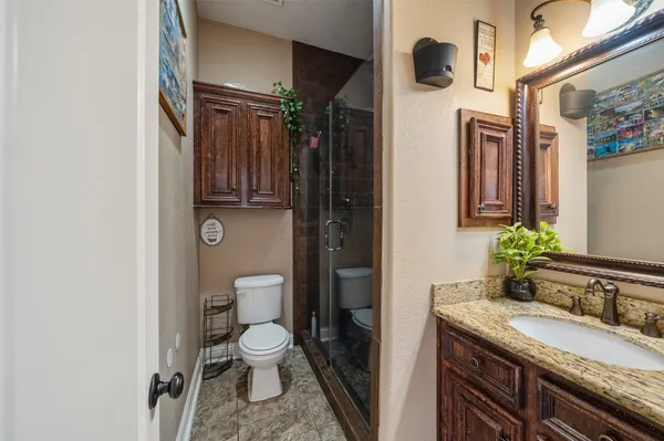 a bathroom with a granite countertop sink toilet and shower curtains