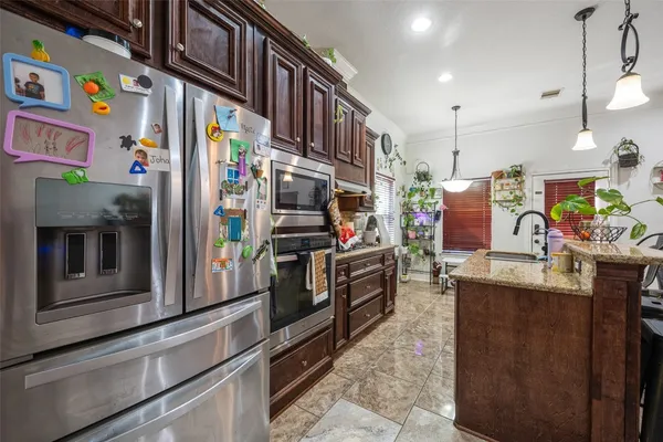 a kitchen with stainless steel appliances granite countertop a refrigerator and a stove