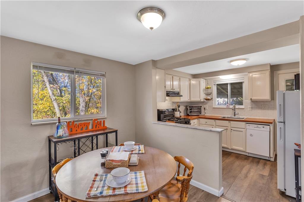 3779 Northern Pike Monroeville, PA 15146 - Photo 11 of 31 a kitchen with stainless steel appliances kitchen island granite countertop a stove a sink a dining table and chairs with wooden floor