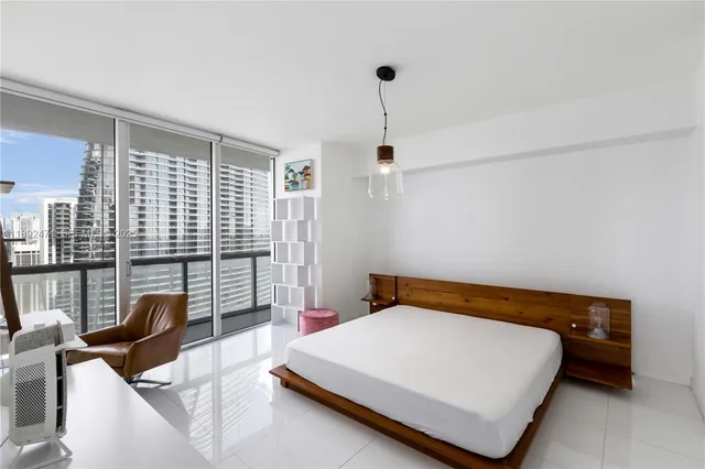 a bedroom with a bed and large windows