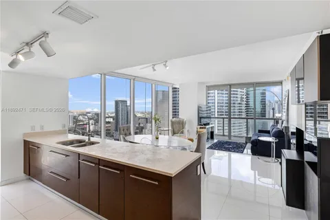 a kitchen with a stove a kitchen island a sink and white cabinets with wooden floor