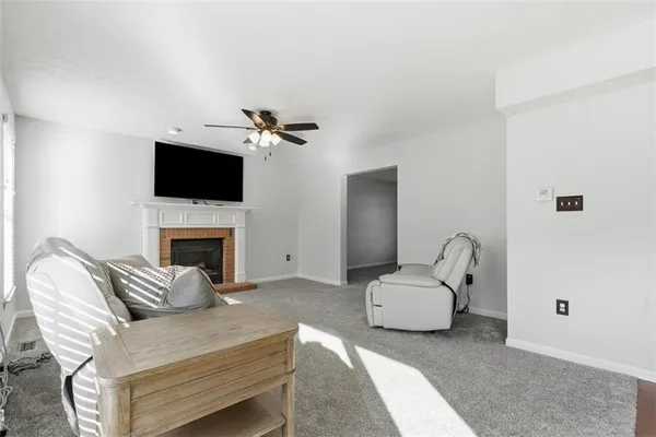 a living room with furniture a flat screen tv and a fireplace