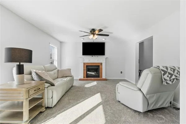 a living room with furniture a fireplace and a flat screen tv