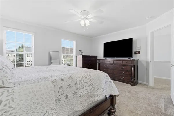 a bedroom with a bed and a flat screen tv on dresser
