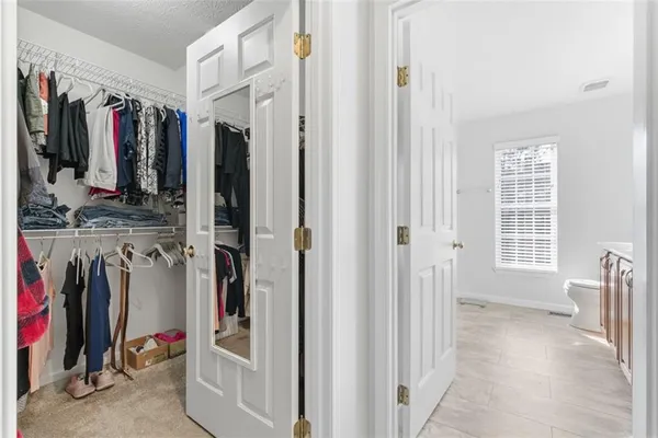 a view of walk in closet with clothes