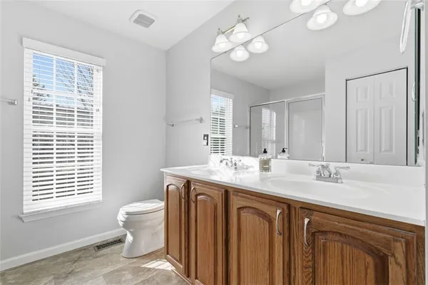 a bathroom with a granite countertop sink a toilet and a mirror