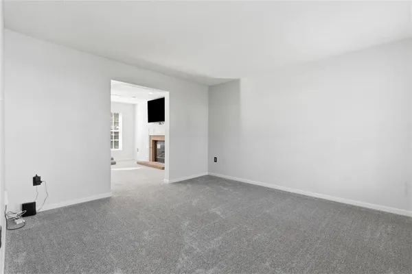 an empty room with a fireplace and entryway