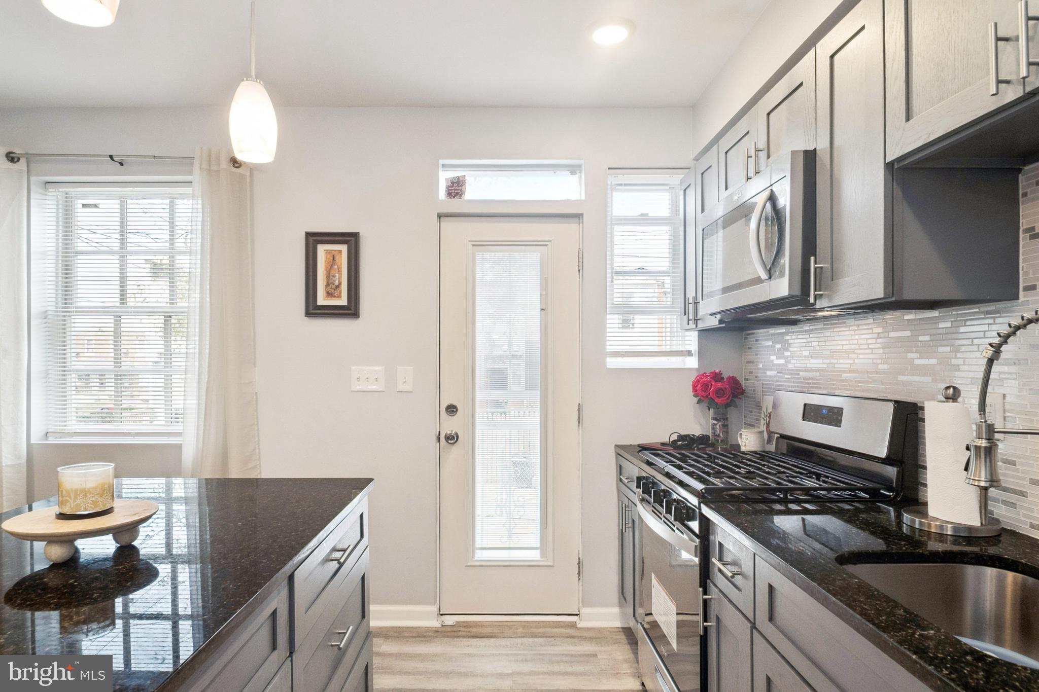 3404 Lyndale Avenue Baltimore, MD 21213 - Photo 14 of 25 a kitchen with granite countertop a stove a sink and a refrigerator
