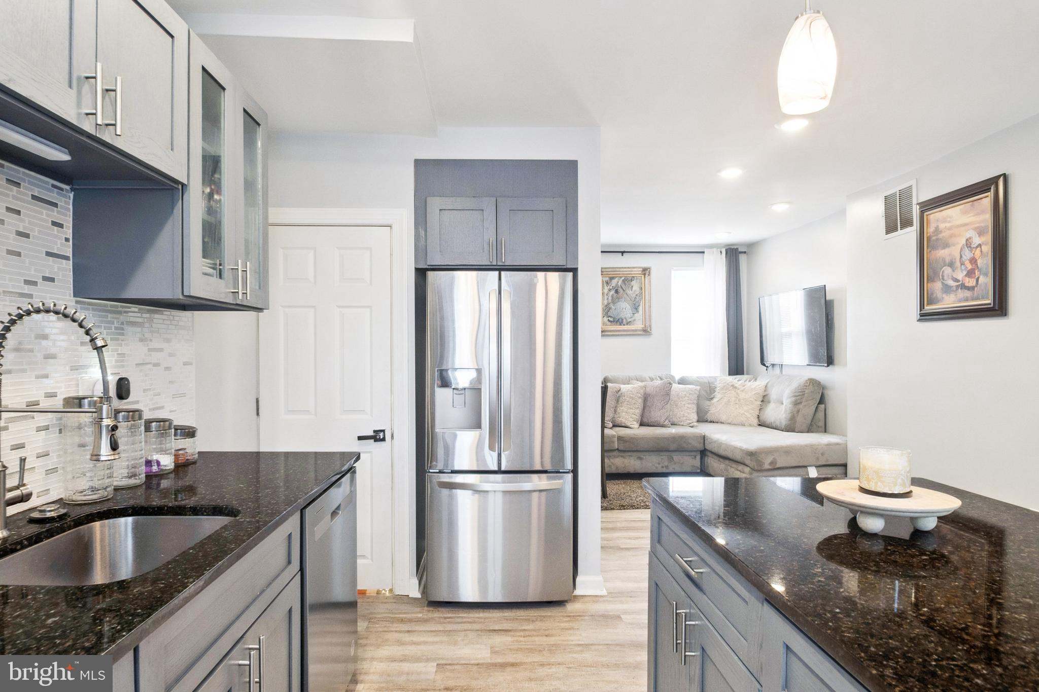 3404 Lyndale Avenue Baltimore, MD 21213 - Photo 15 of 25 a kitchen with granite countertop stainless steel appliances a refrigerator a sink a stove and cabinets