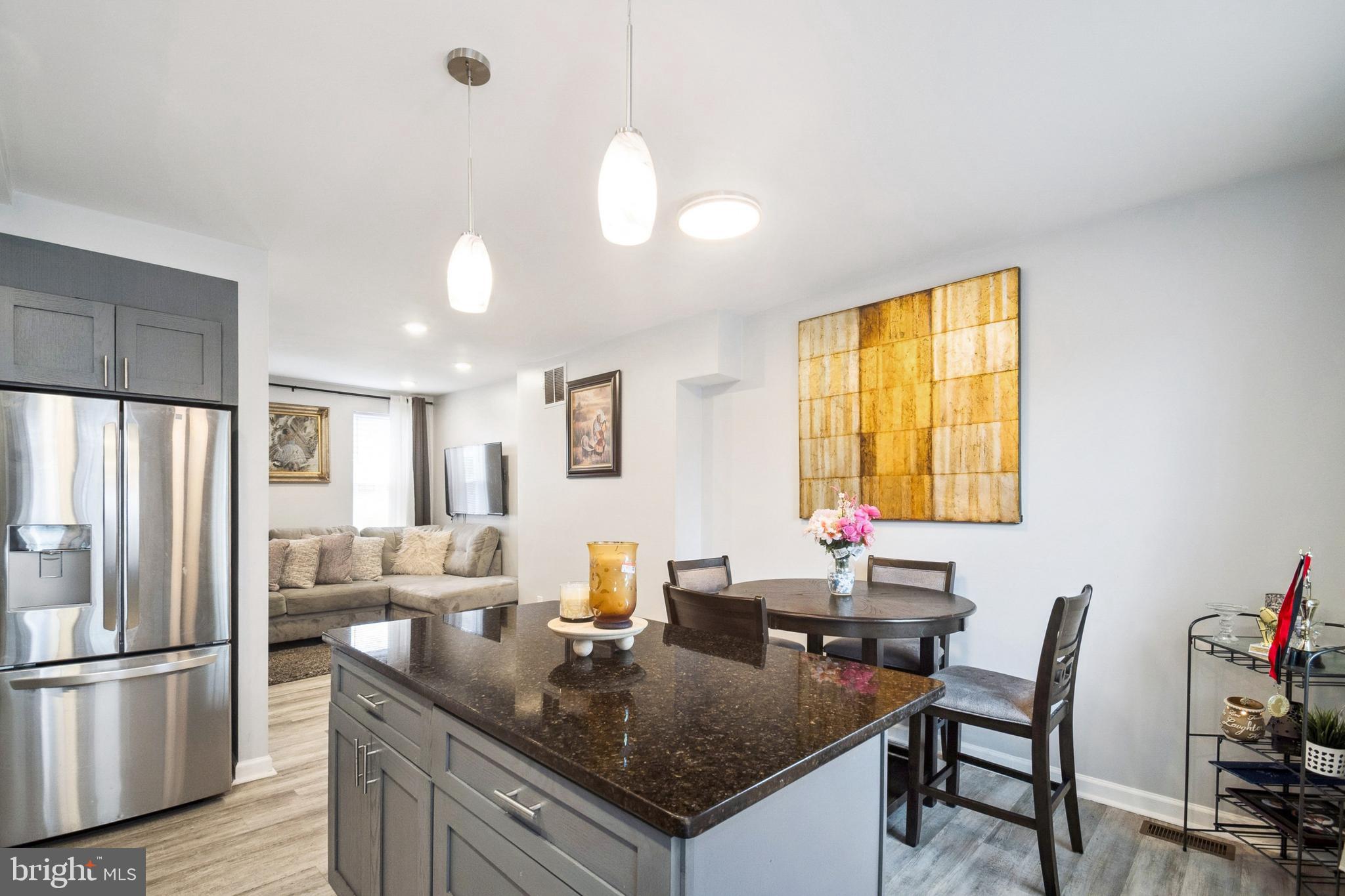3404 Lyndale Avenue Baltimore, MD 21213 - Photo 7 of 25 a kitchen with a table chairs refrigerator and cabinets