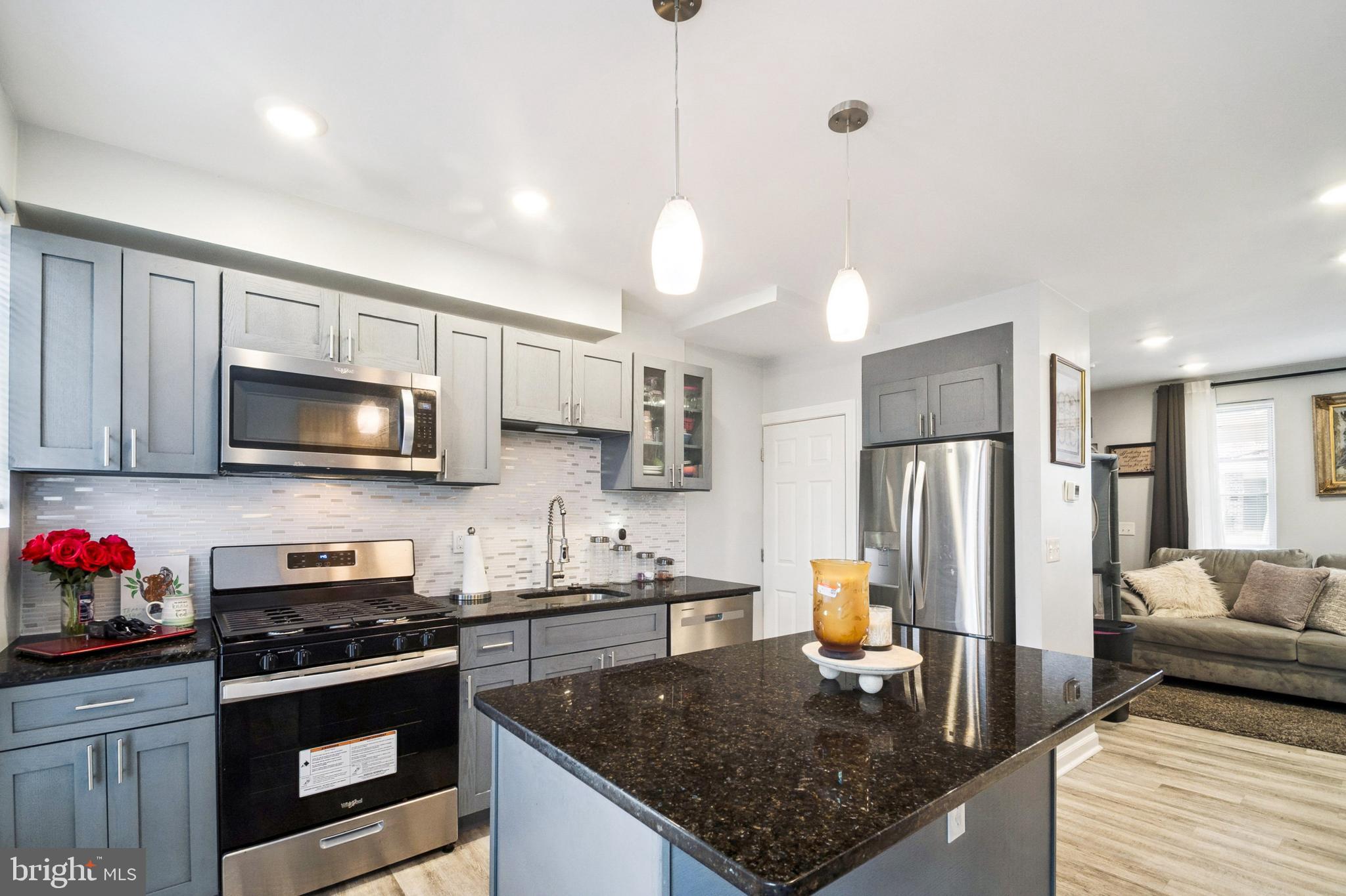 3404 Lyndale Avenue Baltimore, MD 21213 - Photo 8 of 25 a kitchen with stainless steel appliances granite countertop a sink refrigerator and microwave