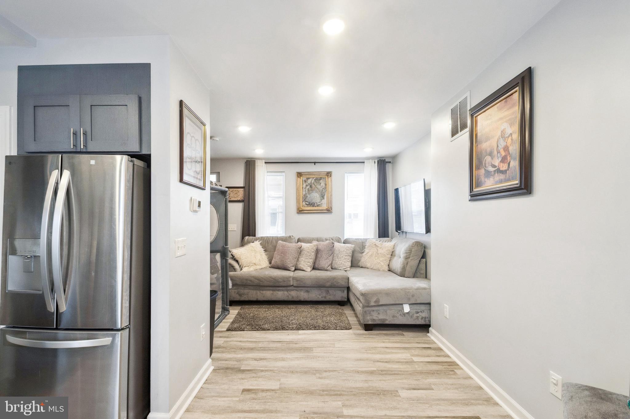 3404 Lyndale Avenue Baltimore, MD 21213 - Photo 9 of 25 a living room with a couch and a refrigerator