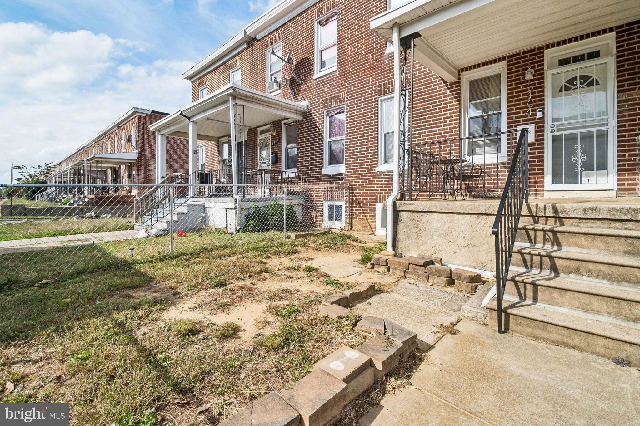 3404 Lyndale Avenue Baltimore, MD 21213 - Photo 10 of 25 a view of a white house with large windows next to a yard
