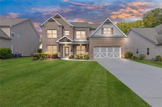 a front view of a house with a garden and plants