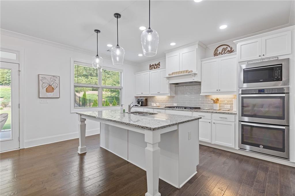 4867 Hunters Grove Way Sugar Hill, GA 30518 - Photo 19 of 61 a kitchen with a stove a sink and a refrigerator
