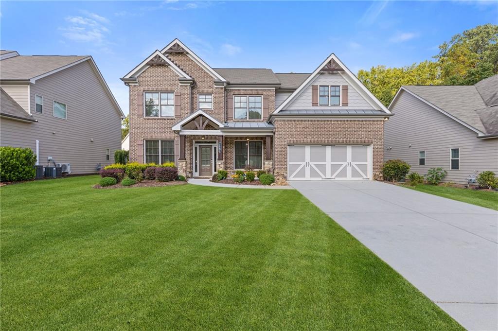 4867 Hunters Grove Way Sugar Hill, GA 30518 - Photo 2 of 61 a front view of a house with a yard table and chairs