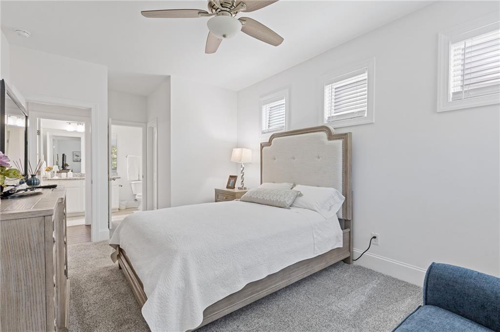 4867 Hunters Grove Way Sugar Hill, GA 30518 - Photo 26 of 61 a bedroom with a bed and a chandelier