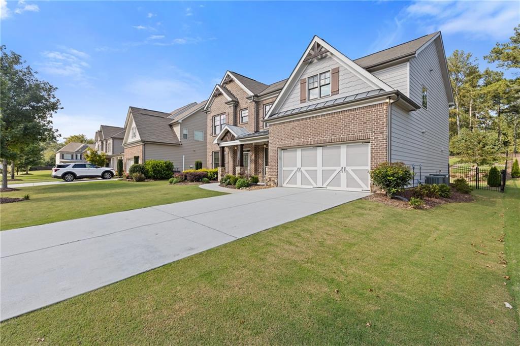 4867 Hunters Grove Way Sugar Hill, GA 30518 - Photo 3 of 61 a front view of a house with a garden