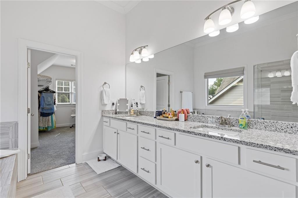 4867 Hunters Grove Way Sugar Hill, GA 30518 - Photo 34 of 61 a bathroom with a double vanity sink and a mirror