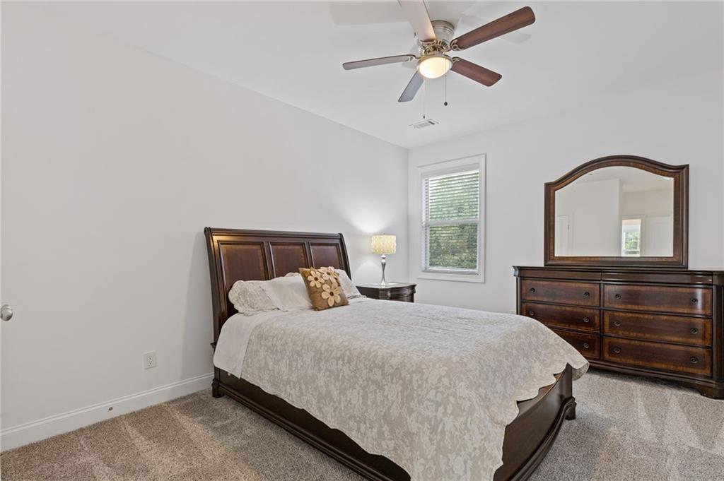 4867 Hunters Grove Way Sugar Hill, GA 30518 - Photo 41 of 61 a bedroom with a bed and a dresser