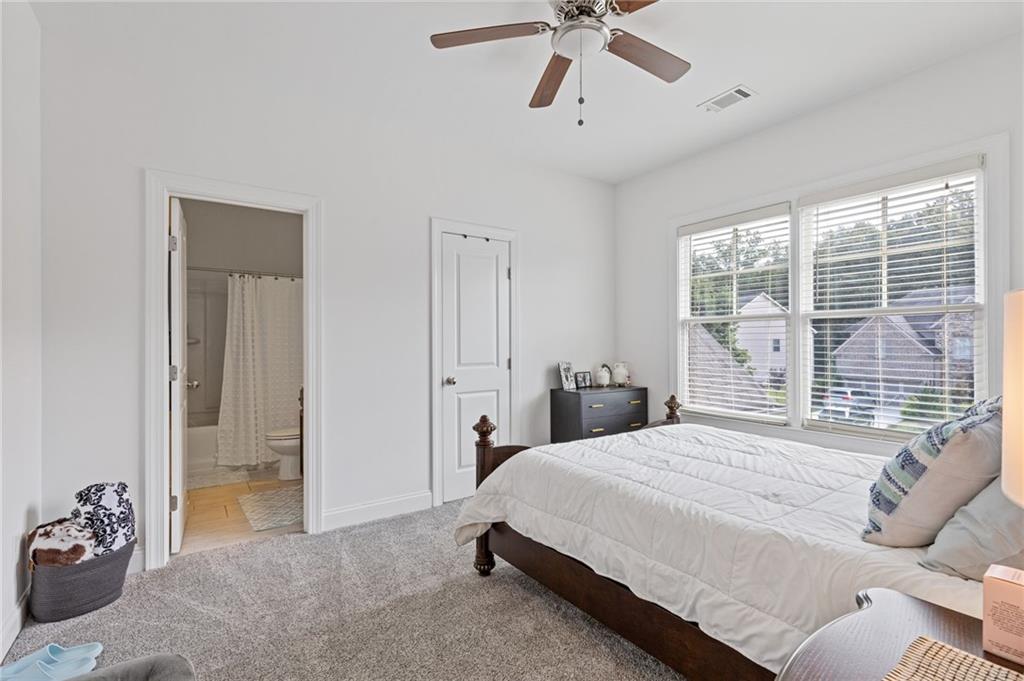 4867 Hunters Grove Way Sugar Hill, GA 30518 - Photo 46 of 61 a bedroom with a bed and a large window