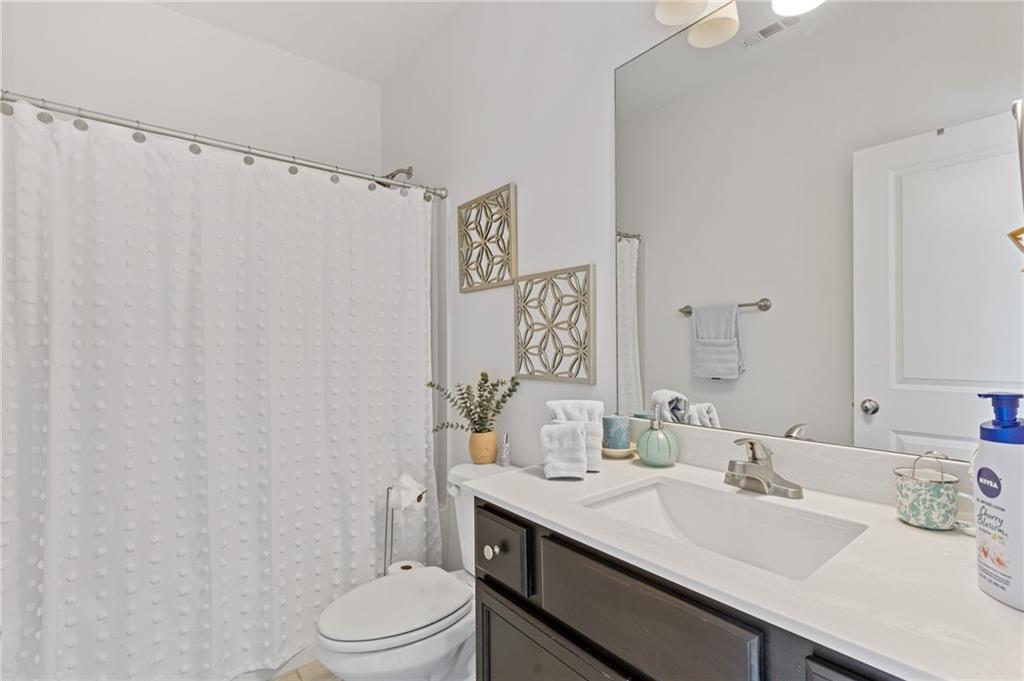 4867 Hunters Grove Way Sugar Hill, GA 30518 - Photo 47 of 61 a bathroom with a sink vanity mirror and toilet