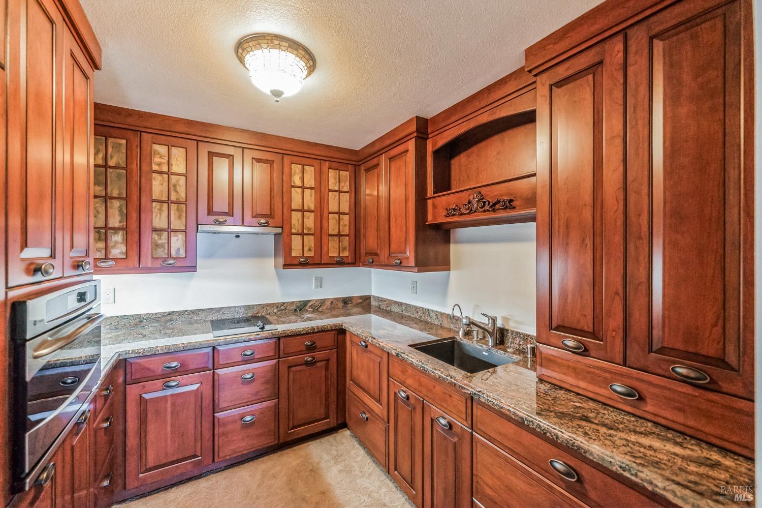 a kitchen with stainless steel appliances granite countertop wooden cabinets a sink and a large window