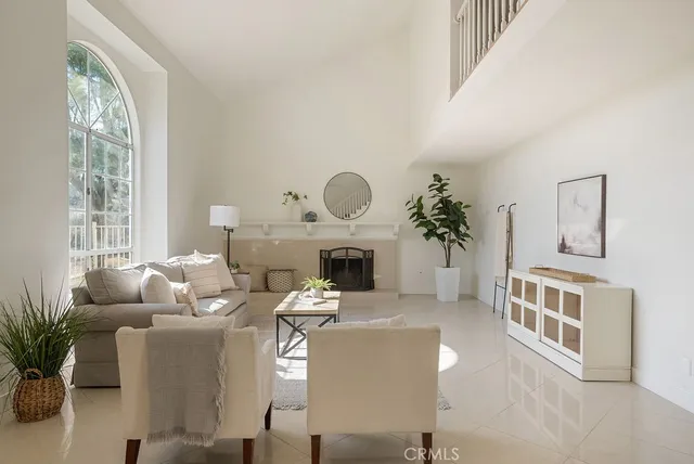 a living room with furniture a fireplace and a large window