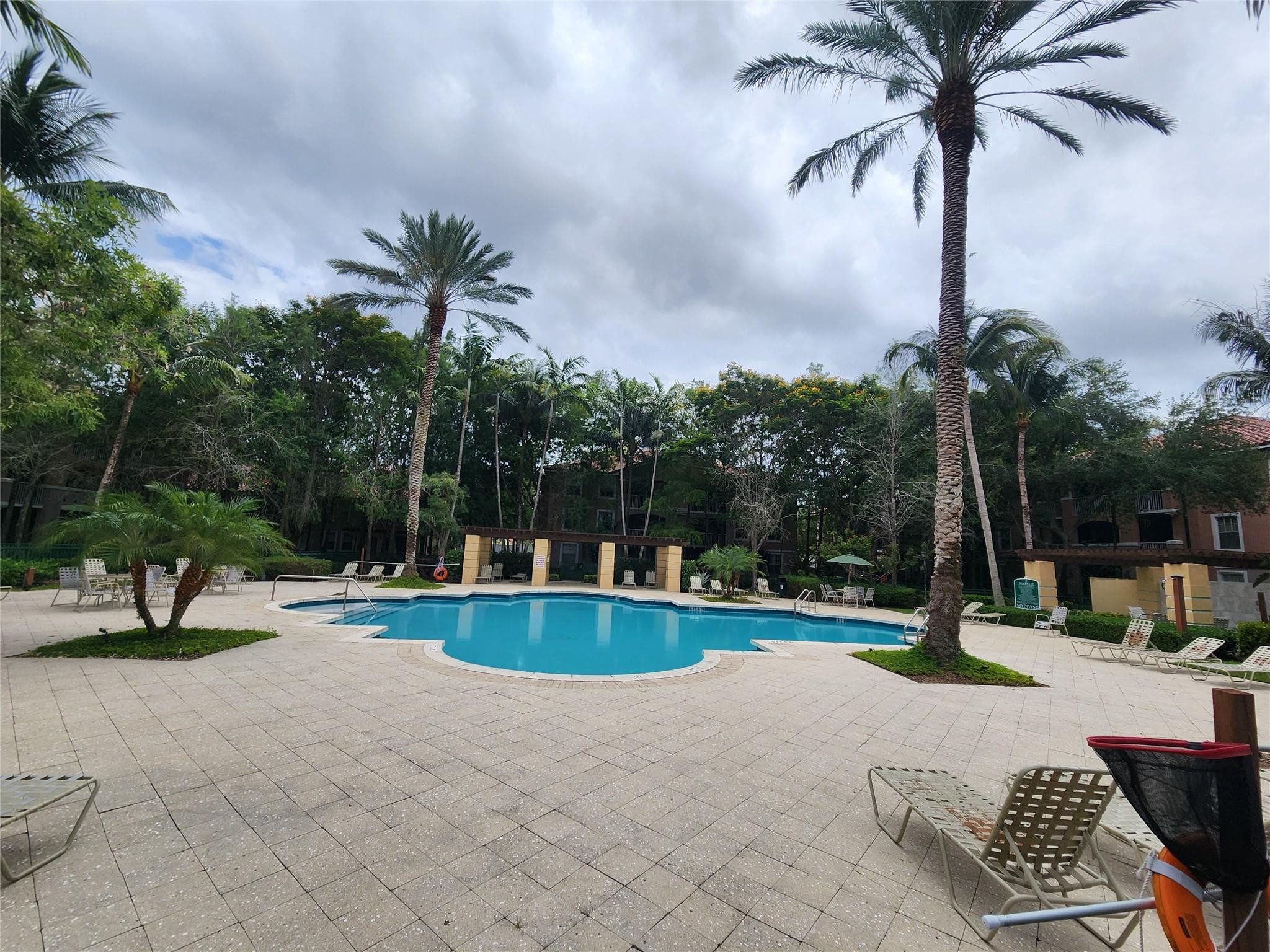 6778 West Sample Road, Unit 6778 Pompano Beach, FL 33067 - Photo 3 of 20 a swimming pool with outdoor seating and yard