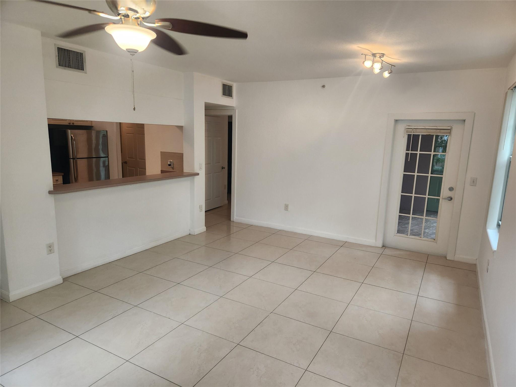 6778 West Sample Road, Unit 6778 Pompano Beach, FL 33067 - Photo 9 of 20 a view of a livingroom with a ceiling fan and chandelier fan