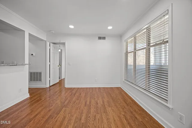 a view of a room with wooden floor and a window