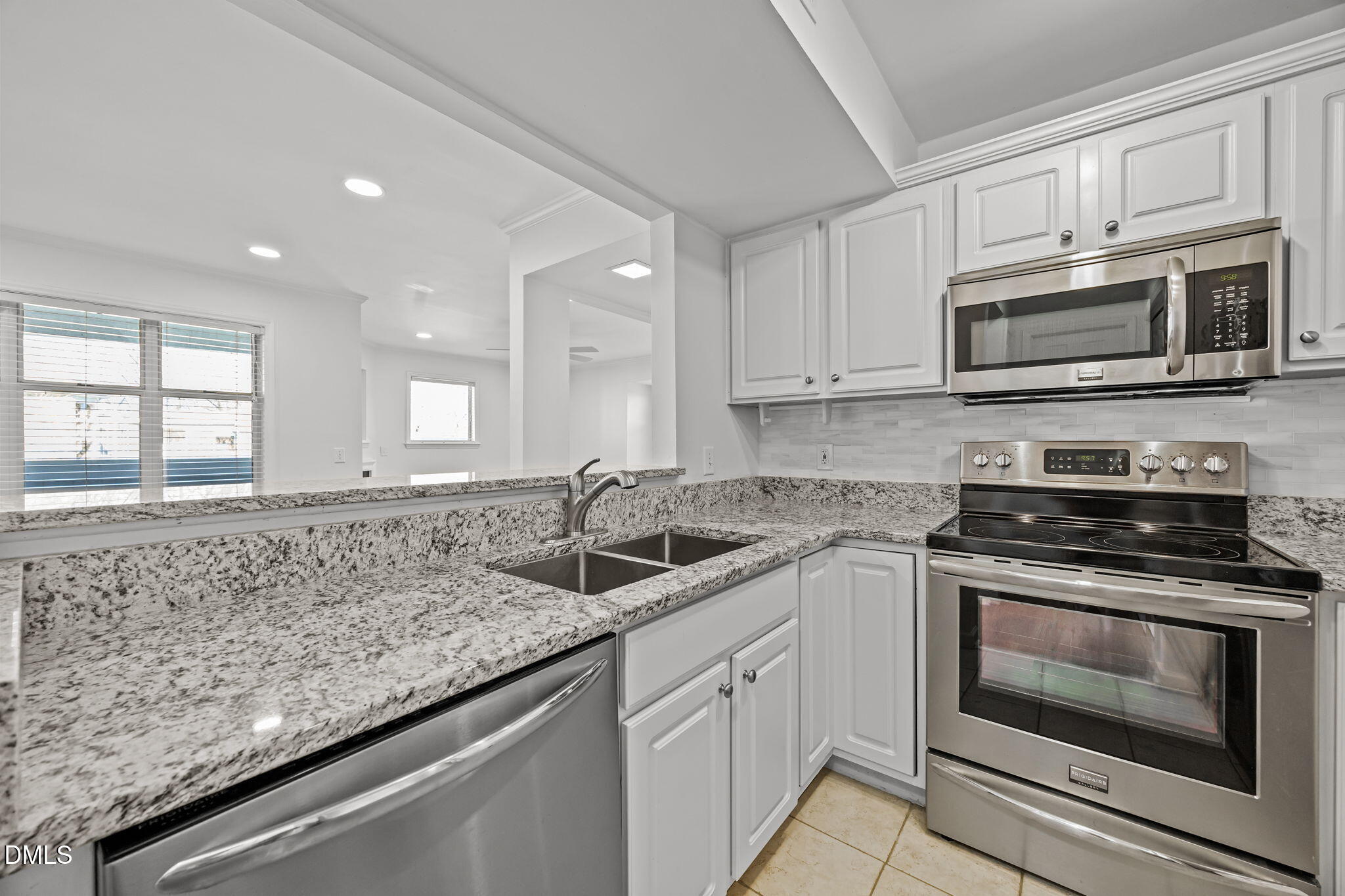 1210 Westview Lane, Unit 309 Raleigh, NC 27605 - Photo 15 of 42 a kitchen with stainless steel appliances granite countertop a sink stove oven microwave and cabinets