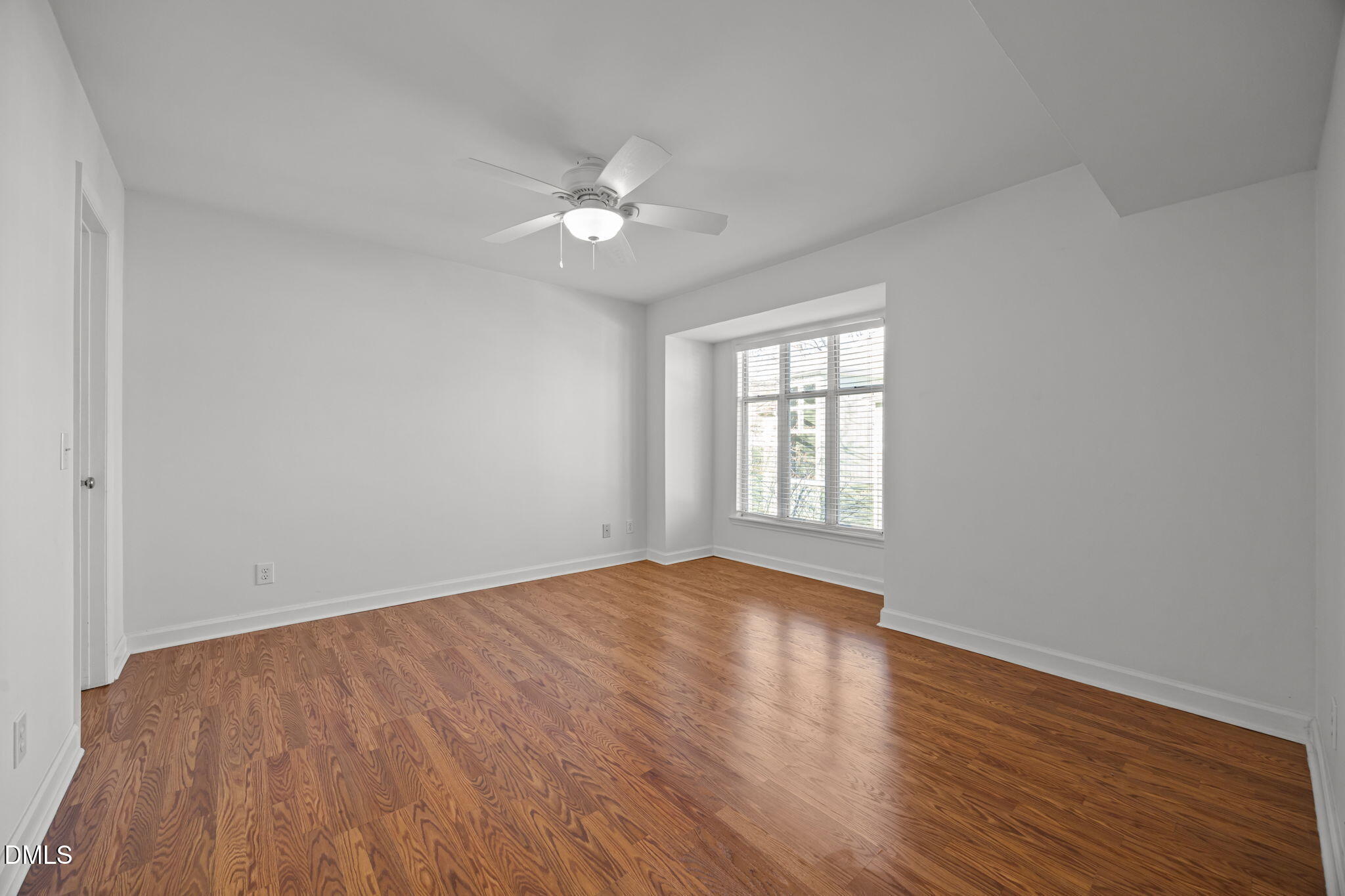 1210 Westview Lane, Unit 309 Raleigh, NC 27605 - Photo 17 of 42 a view of an empty room with wooden floor and a window