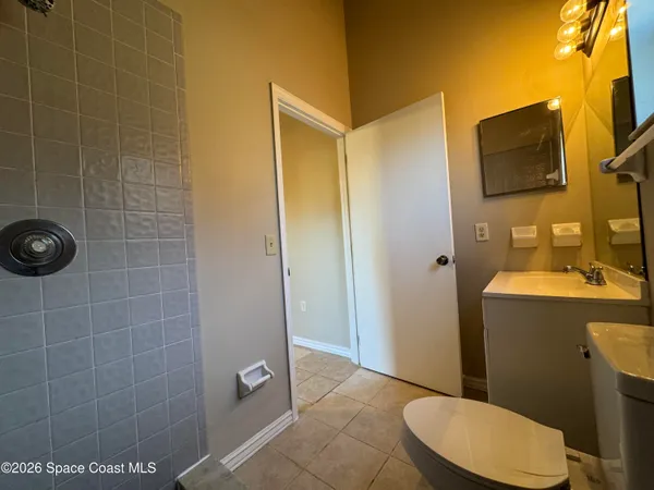 a bathroom with a toilet a sink and mirror