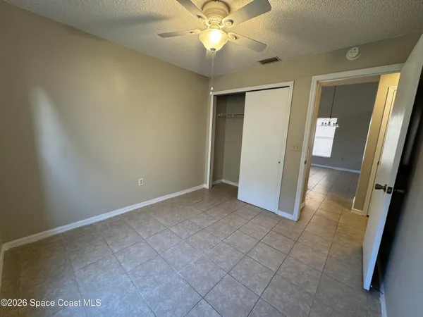 an empty room with a mirror and a ceiling fan