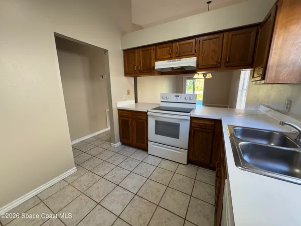 a kitchen with granite countertop a sink a stove and cabinets