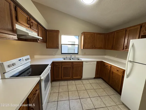 a kitchen with a sink a stove top oven and cabinets