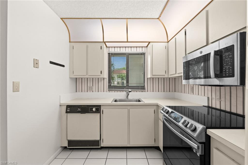 4251 27th Court Southwest, Unit 104 Naples, FL 34116 - Photo 11 of 22 a kitchen with a sink and cabinets