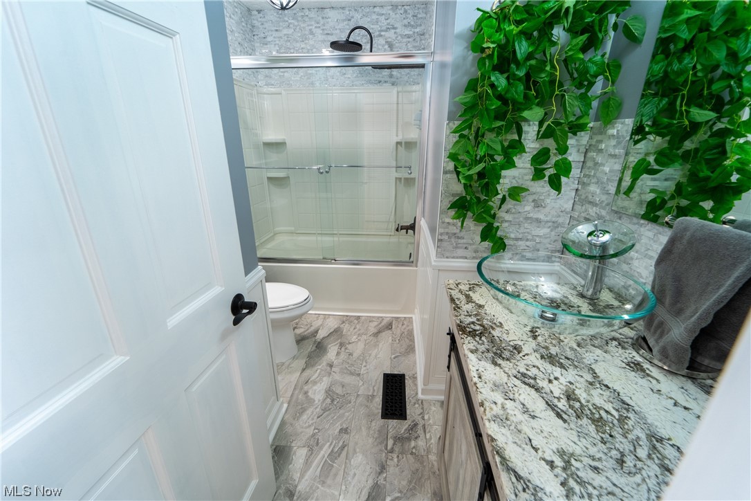 44790 Middle Ridge Road Amherst, OH 44001 - Photo 18 of 23 Full bathroom with combined bath / shower with glass door, light tile floors, and vanity