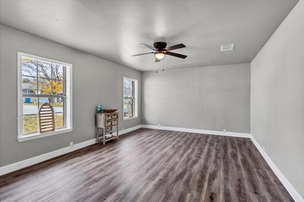 736 Bullock Street Denison, TX 75020 - Photo 3 of 21 wooden floor in an empty room with a window