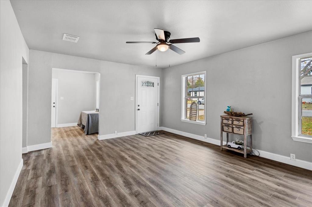 736 Bullock Street Denison, TX 75020 - Photo 5 of 21 a view of an empty room with a window and wooden floor