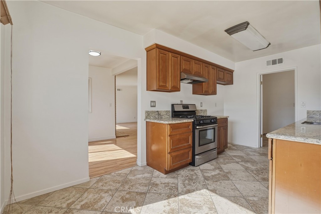 14808 Aztec Street Sylmar, CA 91342 - Photo 16 of 23 a kitchen with stainless steel appliances granite countertop a stove a sink and a refrigerator