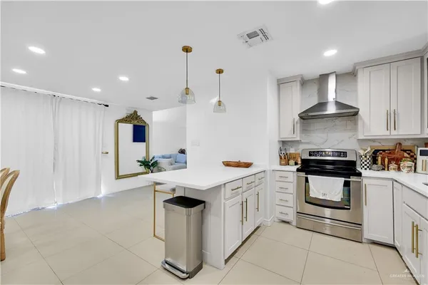 a kitchen with stainless steel appliances kitchen island granite countertop a stove a sink and a refrigerator