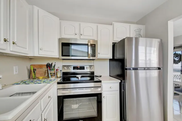 a kitchen with white cabinets and stainless steel appliances