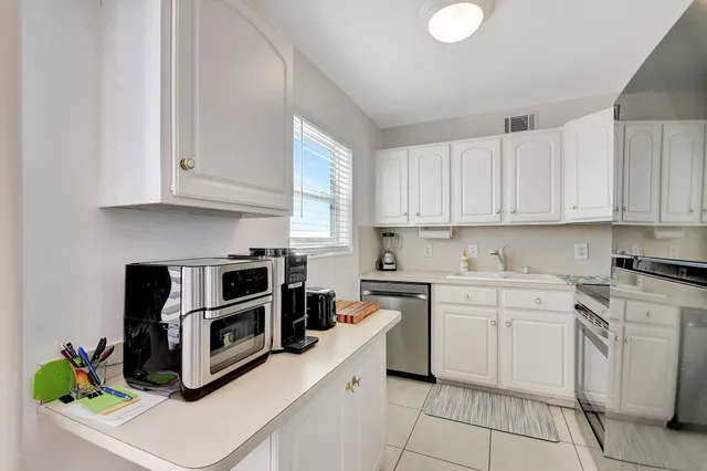 a kitchen with cabinets appliances and a window